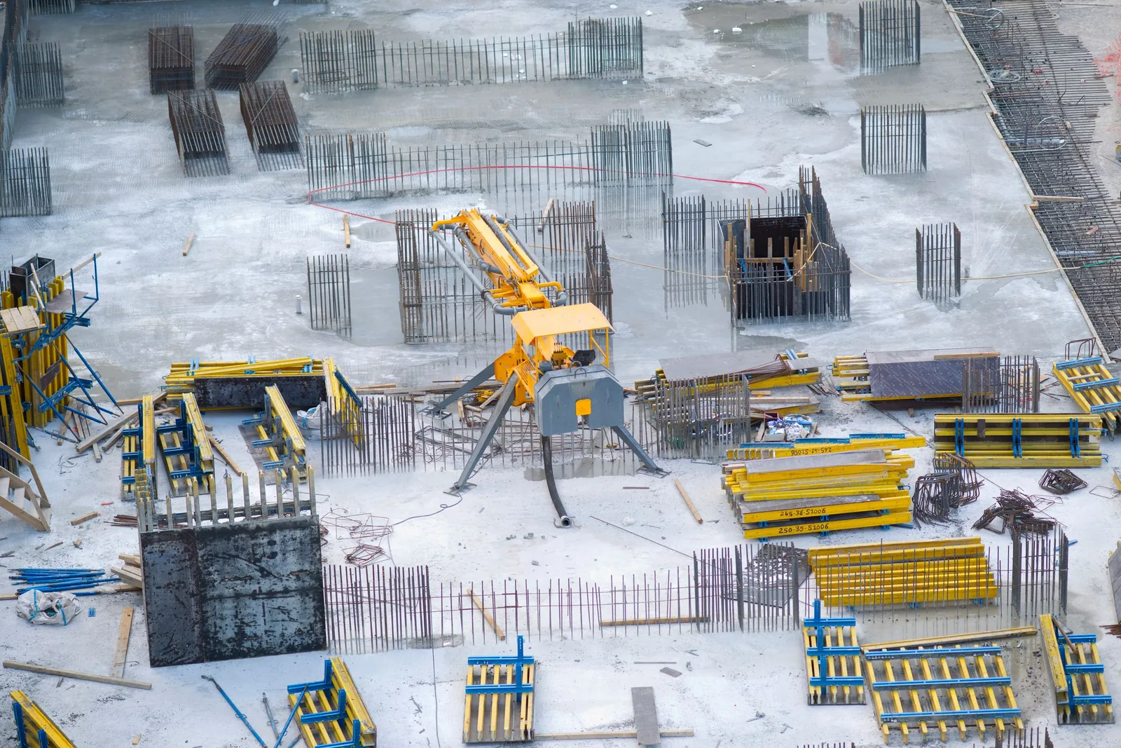Aerial view of a building site with cranes and foundations